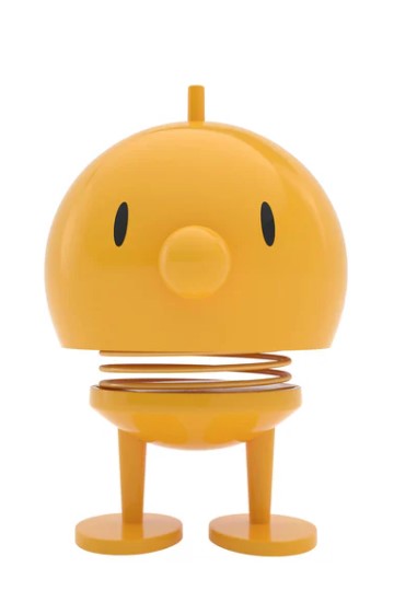 A yellow cartoon-like character statue on a white background