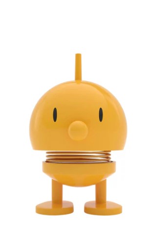 A yellow cartoon-like character statue on a white background