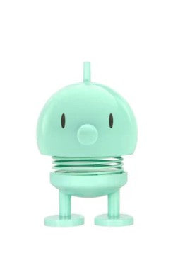 Mint cartoon-like character statue on a white background.