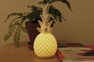 Porcelain LED pineapple appears white when turned off and glows warmly when switched on