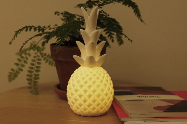 Porcelain LED pineapple appears white when turned off and glows warmly when switched on